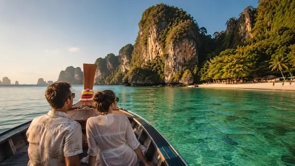 Couple exploring tropical islands by traditional longtail boat during a Couples Phuket Holiday in Thailand