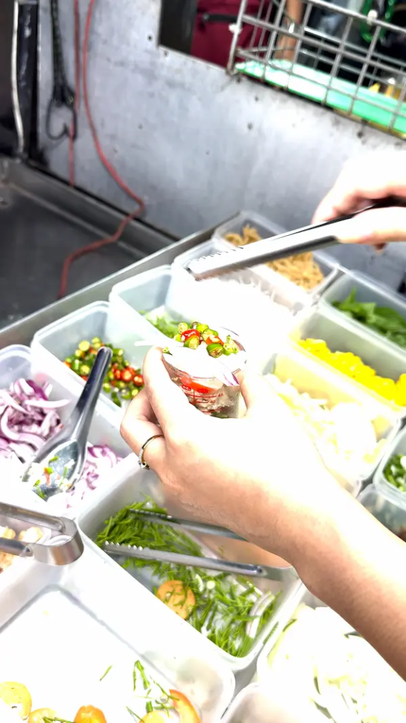 Selecting ingredients for a Kai Jeow Thai omelette at a street food stall in Phuket