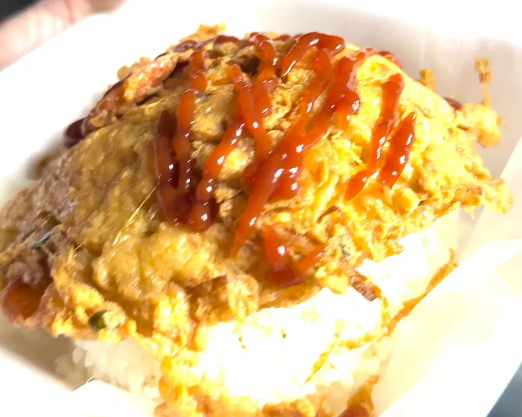 Kai Jeow Thai omelette served in a takeaway container at a street food stall in Phuket, Thailand