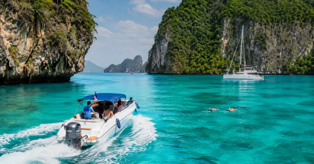 Speedboat, snorkellers and catamaran exploring limestone islands during Phuket tours and experiences in the Andaman Sea